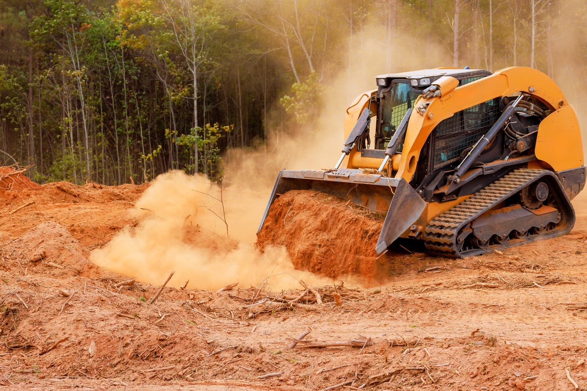 Heavy machinery clearing wooded area